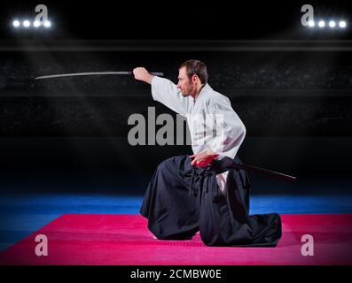 Aikido Kämpfer mit Schwert in der Sporthalle Stockfoto