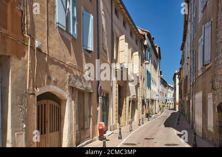 Eine sonnendurchflutete Seitenstraße mit klassischen alten Türen, Fenstern und Fensterläden in der alten Millau-Stadt, Aveyron, Frankreich Stockfoto