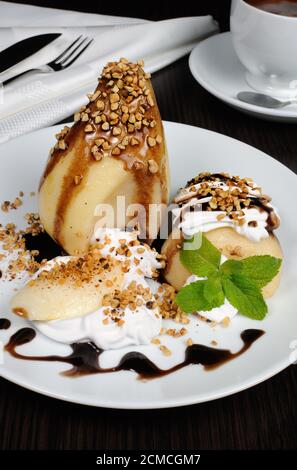 Birne mit Schlagsahne und Nüssen Stockfoto