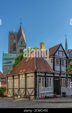 Ein Fachwerkhaus und die Ribe-Kathedrale mit ihren zwei Türmen im Hintergrund, Ribe, Dänemark, 1. Juni 2020 Stockfoto