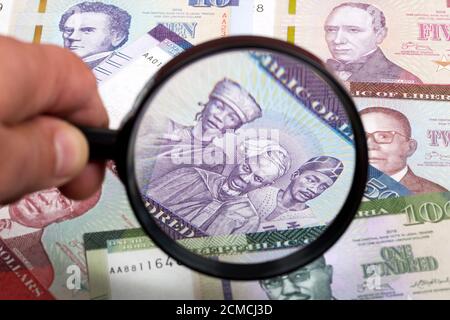 Liberianische Geld in einer Lupe ein geschäftlicher Hintergrund Stockfoto