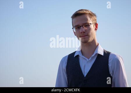 Junger Mann mit Brille in weißem Hemd und Weste Stockfoto
