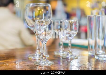 Mehrere Gläser auf dem Tisch. Leeres sauberes Glas für Weinreben und kurze Getränke an der Bar. Selektiver Fokus Stockfoto