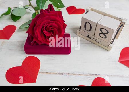 Schmuckschatulle mit und schönen roten Rosen auf Holzhintergrund. Grußkarte für den 8. März. Stockfoto