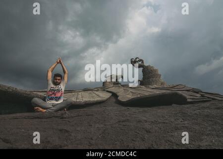 KOLLAM, INDIEN - 11. Sep 2019: Ein indischer Mann meditiert neben der weltweit größten Adlerstatue namens Jatayu in Kollam, Kerala Stockfoto