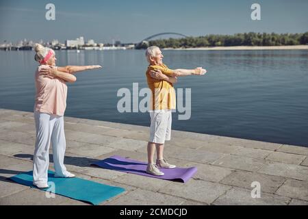 Fröhliche Frau und ihr Mann arbeiten draußen Stockfoto