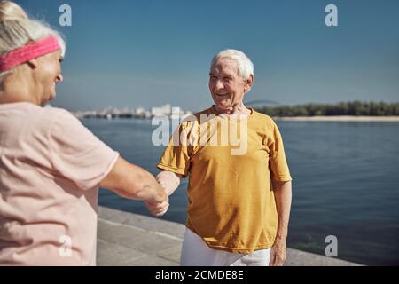 Frau begrüßt einen Mann am Kai Stockfoto