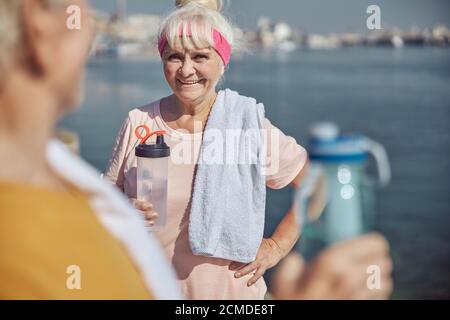 Lächelnde sportliche Frau, die neben einem grauhaarigen Mann steht Stockfoto