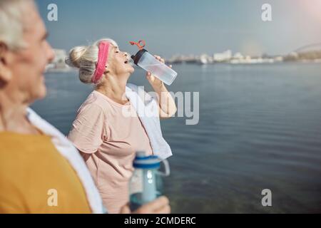 Frau, die verlorene Elektrolyte nach dem Training wieder auffüllt Stockfoto
