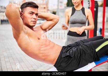 Muskulös gut aussehend Kerl tun abs knirscht im Freien Stockfoto