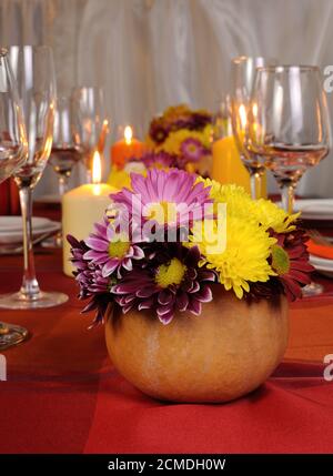 Herbstblumen in einer Vase auf dem Tisch mit Kürbis Stockfoto