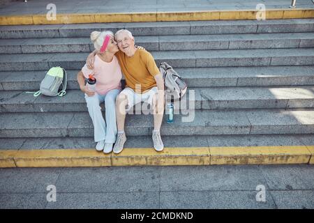 Liebevolle alte Ehepartner sitzen auf der Treppe Stockfoto