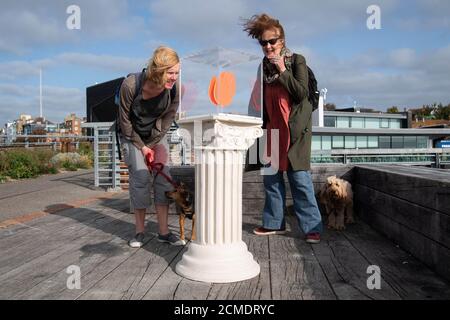 Passanten sehen sich eine Arbeit von Maureen Jordan an der Uferpromenade von Folkestone im Rahmen des neuen Kunstprojekts von Creative Folkestone namens The Plinth an – sie platzieren 10 freie Sockel an verschiedenen Orten rund um die Küstenstadt und laden Bewohner und Besucher dazu ein, sie zu nutzen, um ihr künstlerisches Talent zu zeigen, Anlässlich der Neuinstallation von Art Buff, einem Gemälde des Straßenkünstlers Banksy, auf der Old High Street von Folkestone. Stockfoto