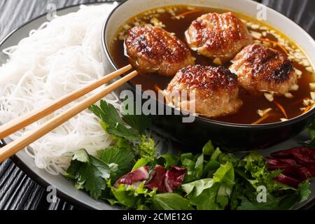 Bun Cha, die berühmten karamellisierten Fleischbällchen aus den Straßen von Hanoi. Traditionelles vietnamesisches Essen aus der Nähe auf dem Tisch. Horizontal Stockfoto