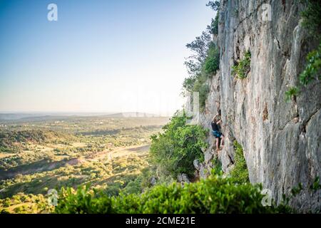 Mann klettert einen Felsen mit Ausrüstung in Portugal Stockfoto