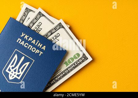 Ukrainischer Pass mit Haufen amerikanischer Dollar im Inneren Stockfoto