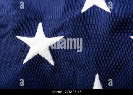 Makroaufnahme eines weißen gestickten Sterns auf dem Blau der US-amerikanischen Flagge, der den Hintergrund für die Verwendung, US-Veteranen oder den Unabhängigkeitstag symbolisiert Stockfoto