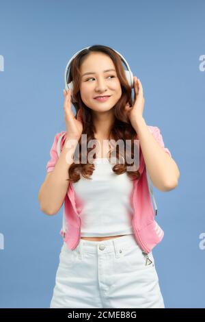 Ziemlich cool Mädchen Spaß und hört Musik in den Kopfhörern, Tanz über blauen Hintergrund. Stockfoto