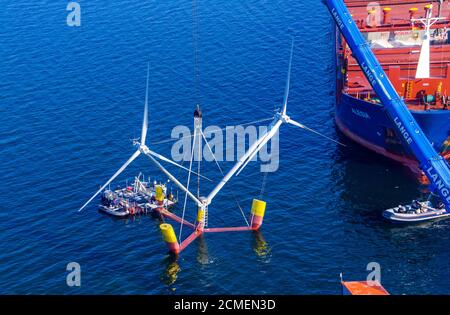 16. September 2020, Mecklenburg-Vorpommern, Vierow: Ein Kran hebt ein Modell einer Anlage mit schwimmenden Windkraftanlagen im Hafen ins Wasser. (Luftaufnahme mit Drohne) die Testanlage ist im Greifswalder Bodden verankert. Das Energieunternehmen EnBW und der Schleswig-holsteinische Windturbinenhersteller Aerodyn Engineering wollen nun Nezzy2 im Meer mit Wellen testen. Das Forschungsprojekt umfasst eine neue Offshore-Technologie, in der die Windenergieanlagen auf dem Wasser schwimmen. Bislang sind Offshore-Turbinen fest auf Stahlrahmen im Meeresboden verankert. Die Modellanlage ist mit t ausgestattet Stockfoto