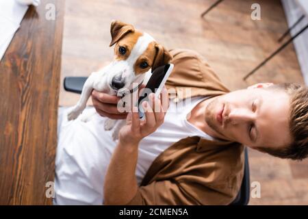 High-Angle-Ansicht des Geschäftsmannes hält Handy in der Nähe des Ohrs jack russell Terrier Hund Stockfoto