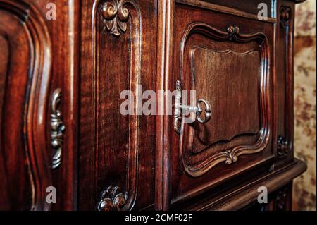 Schlüssel und Tür zu einem alten Holzschrank Stockfoto