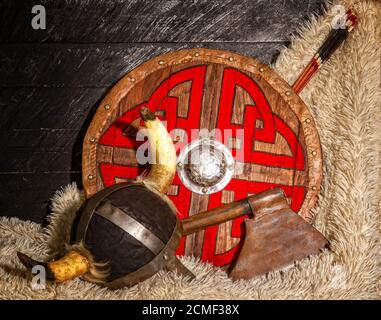 Stahl Axt gehörnten Helm und Holz wikinger Schild mit Muster Stockfoto