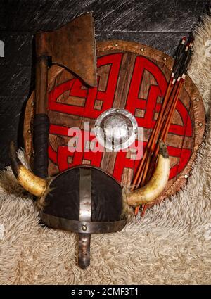 Stahl Axt gehörnten Helm und Holz wikinger Schild mit Muster Stockfoto