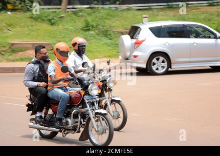 Kampala, Uganda. September 2020. Ein gewerblicher Motorradfahrer trägt einen Passagier in Kampala, der Hauptstadt Ugandas, 16. September 2020. Kommerzielle Motorradfahrer in Uganda haben den Online-Buchungsservice verstärkt, um ihre Kunden inmitten der COVID-19-Pandemie weiterhin zu bedienen. Quelle: Nicholas Kajoba/Xinhua/Alamy Live News Stockfoto