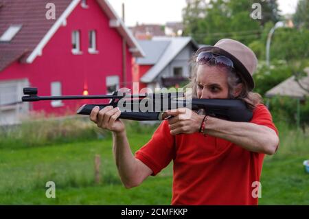 Junger Mann schießt draußen mit Luftgewehr Stockfoto