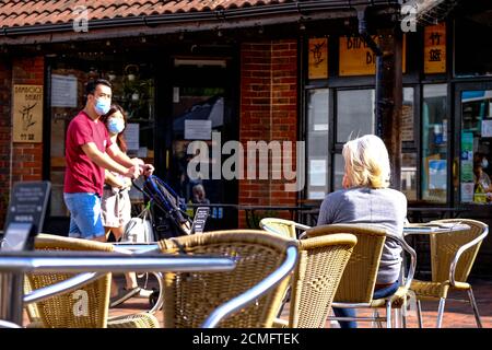 Menschen draußen und in EINEM Cafe entspannen tragen Schutzgesicht Abdeckungen oder Masken während COVID-19 Stockfoto