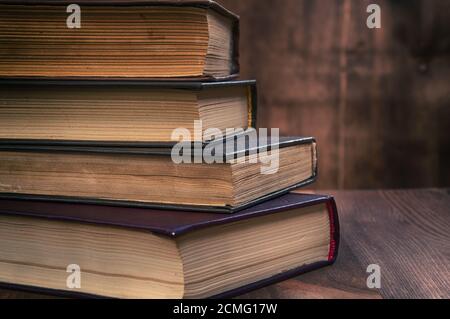 Stapel alter Bücher auf einem braunen Holz- Hintergrund Stockfoto