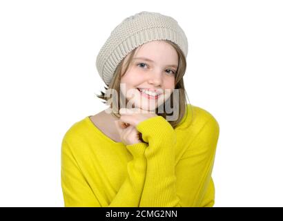 Porträt eines niedlichen Teenagers in einem gelben Pullover und einer Strickmütze. Stockfoto