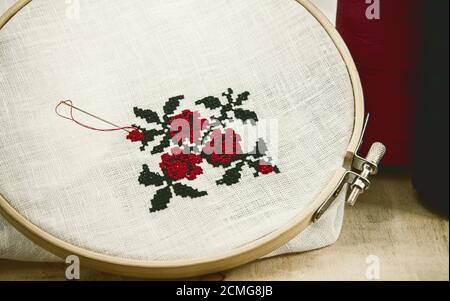 Hand Stickerei Kreuz-Stich Blume Ornament auf einem weißen Stoff Stockfoto