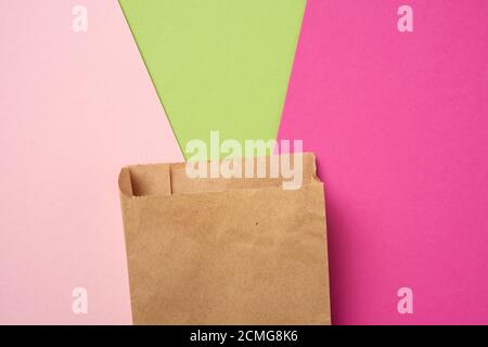 Braune Papier Einweg-Lebensmittelbeutel auf einem rosa Hintergrund, Konzept der Lieferung und Bestellung, Draufsicht Stockfoto