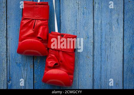 Rote Boxhandschuhe aus Leder, die an einem Seil hängen Stockfoto
