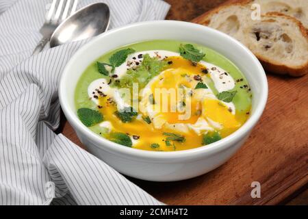 PEA-Püree-Suppe mit pochiertem Ei und Pfefferminze Stockfoto