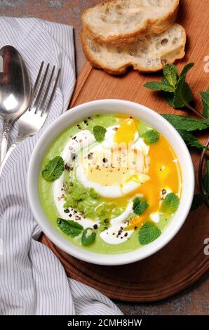 PEA-Püree-Suppe mit pochiertem Ei und Pfefferminze Stockfoto