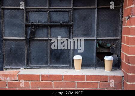 Sheffield, Großbritannien – 30 Nov 2018 : zwei leere Kaffeetassen auf der Fensterbank von Bells Court in der Bailey Street 26 aufgegeben Stockfoto