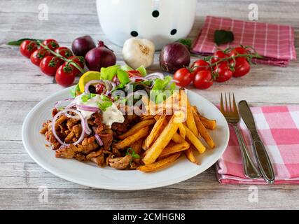 griechischer Gyros-Teller mit pommes Frites und Salat Stockfoto