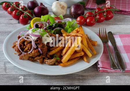 griechischer Gyros-Teller mit pommes Frites und Salat Stockfoto