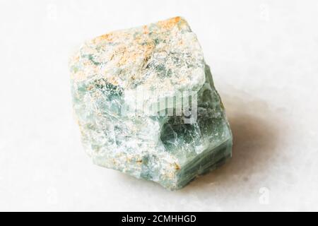 Nahaufnahme der Probe des natürlichen Minerals aus der geologischen Sammlung - Roher Apatit-Stein auf weißem Marmor-Hintergrund Stockfoto