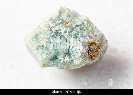 Nahaufnahme der Probe des natürlichen Minerals aus der geologischen Sammlung - Rauer Apatit-Stein auf weißem Marmor-Hintergrund Stockfoto