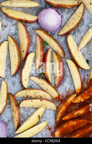 Roh geschnittene Kartoffeln mit Gewürzen, zum Backen gekocht. Stockfoto