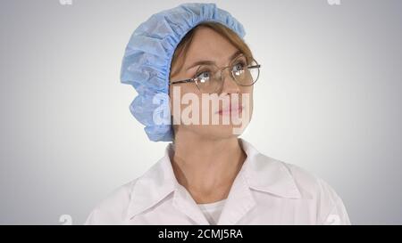 Ärztin in Brille und Hut beim Gehen und Umsehen Auf gr Stockfoto