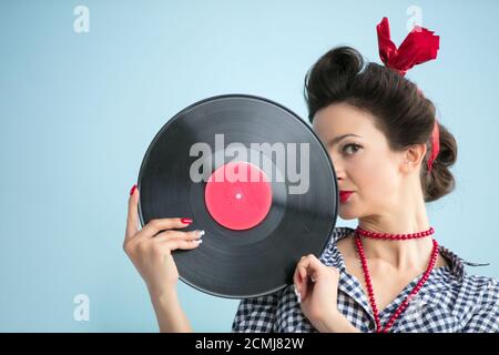 Retro Frau im Stil der 50er Jahre hält eine musikalische Platte. Stockfoto