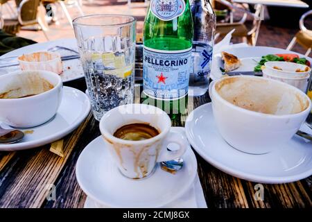 Frühstückstisch Mit Essen Und Flaschen Wasser Mit Leeren Kaffeetassen, Ohne Personen Stockfoto