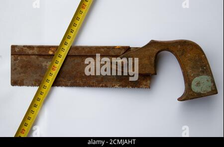 Alte vintage rostige Zentensäge und Maßband isoliert auf Weißer Hintergrund Stockfoto