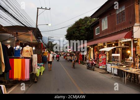 Thailänder und ausländische Reisende zu Fuß reisen besuchen und kaufen Essen und Souvenir-Produkte auf der Straße Nacht Pai Markt Pai Stadt Tal Hügel am Februar Stockfoto