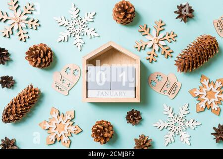 Blick von oben auf die Holz- Kalender, urlaub Spielzeug und Dekorationen auf Blau Weihnachten Hintergrund. Der erste Januar. Neues Jahr Zeit Konzept. Stockfoto