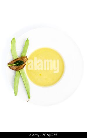 Cremesuppe aus geschmorten Bohnen auf einem weißen Teller auf hellem Hintergrund. Stockfoto